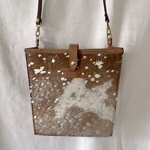 Kell Gallaher hair on hide purse with silver, but hardware is gold. 11”H x 12”W